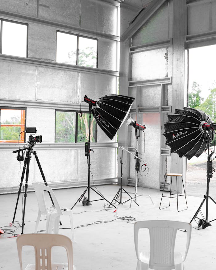 Indoor studio with professional lighting equipment and camera setup, ideal for photoshoots.